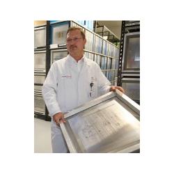 Kierownik produkcji Georg Denkinger z matrycą. Służy ona do kontrolowanego nakładania pasty lutowniczej na płytki drukowane.